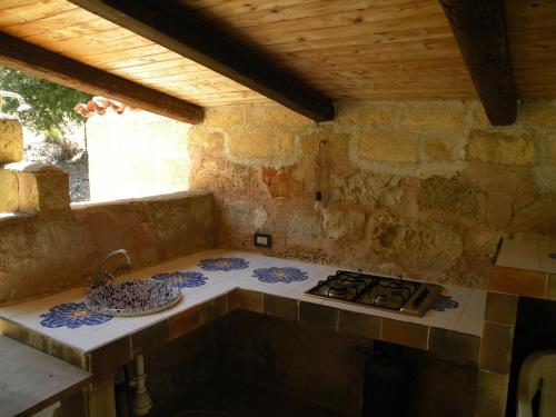 a kitchen counter with a stove and a sink at the ancient sicilian house near zingaro reserve Scopello in Scopello