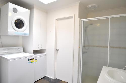 a bathroom with a shower and a washing machine at WAVELENGTH - WIFI & PET FRIENDLY (OUTSIDE ONLY) in Inverloch