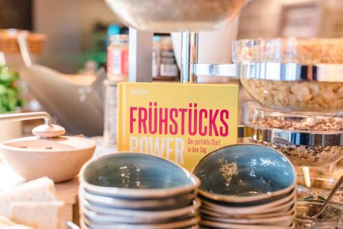 a book sitting on a table with plates and bowls at Hotel Landhaus an de Dün in Sankt Peter-Ording