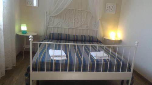 a bedroom with a bed with two lights on it at Forte Village in Marzamemi