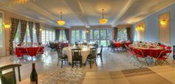 a dining room with tables and chairs in a room at Auberge des Écluses in Carrières-sous-Poissy