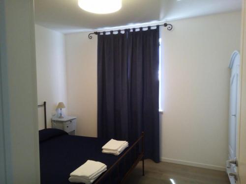 a bedroom with a bed with a blue curtain and a window at Agriturismo La Semente in Spello