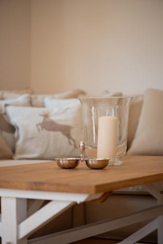 a table with a candle and a glass vase at Grüne Hufe in Born