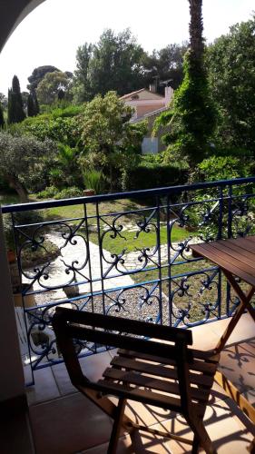 d'un banc sur un balcon avec vue sur le jardin. dans l'établissement villa le grilladou, à Hyères