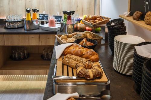 a table topped with lots of different types of bread at AKZENT Hotel Villa Saxer in Goslar