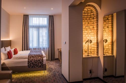 a hotel room with a bed and a window at AKZENT Hotel Villa Saxer in Goslar