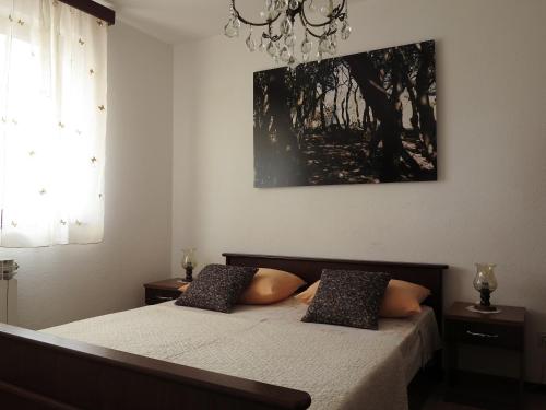 a bedroom with a bed and a painting on the wall at Apartments Potočki in Medulin