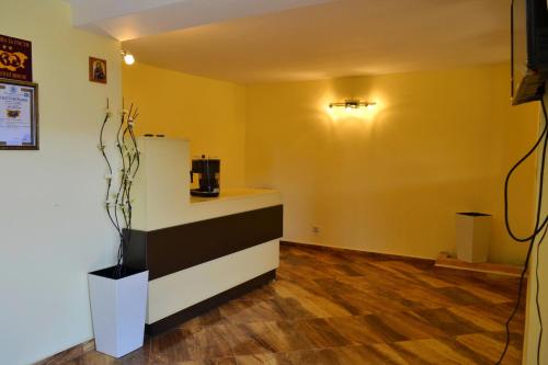 a room with a yellow wall with a counter and a kitchen at Joro Guest House in Sveti Vlas