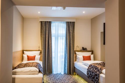 Un pat sau paturi într-o cameră la AKZENT Hotel Villa Saxer