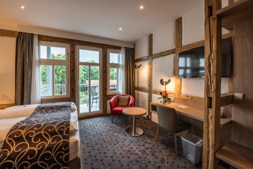 a hotel room with a bed and a desk at AKZENT Hotel Villa Saxer in Goslar
