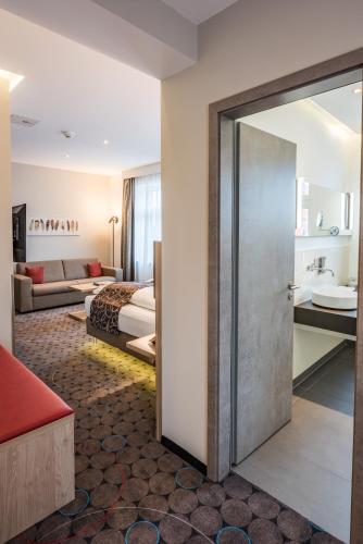 a hotel room with a door leading to a bedroom at AKZENT Hotel Villa Saxer in Goslar