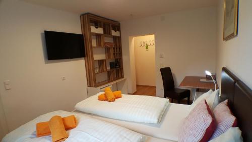 a bedroom with two beds and a table with a desk at Gasthof Klug zum Ehrensepp in Modriach