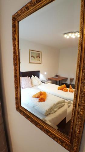 a mirror reflecting a bed with towels on it at Gasthof Klug zum Ehrensepp in Modriach