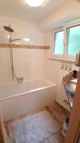 a bathroom with a shower and a tub and a sink at Gasthof Klug zum Ehrensepp in Modriach