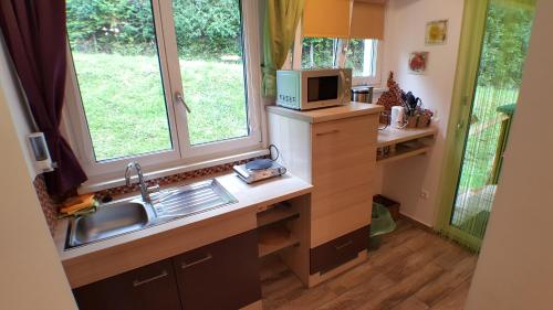 a kitchen with a sink and a microwave at Gasthof Klug zum Ehrensepp in Modriach