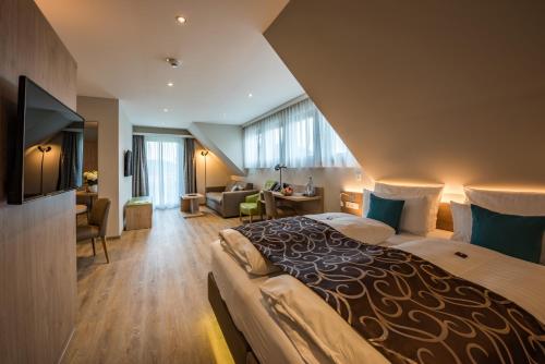 a bedroom with a large bed and a living room at AKZENT Hotel Villa Saxer in Goslar