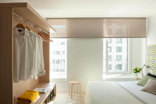 a bedroom with a bed and a robe hanging in a window at Eric Vökel Boutique Apartments - Hamburg Suites in Hamburg