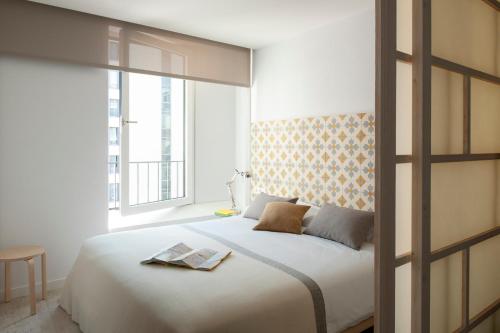 a bedroom with a large white bed and a window at Eric Vökel Boutique Apartments - Hamburg Suites in Hamburg