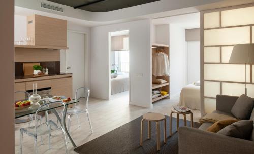 a living room and kitchen with a table and chairs at Eric Vökel Boutique Apartments - Hamburg Suites in Hamburg