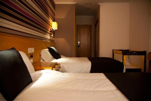 Ένα ή περισσότερα κρεβάτια σε δωμάτιο στο Hotel Palacio de Cristal