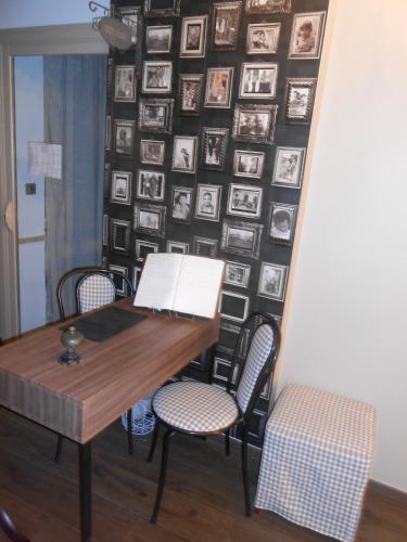 a room with a table and chairs and a wall with pictures at Hôtel-Restaurant "Chez Carrière" in Aigues-Mortes