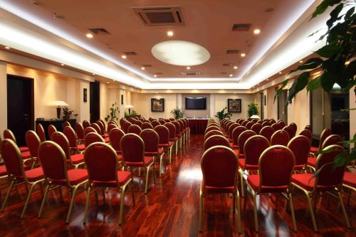 a conference room with red chairs and a television at Monte Casa SPA & Wellness in Petrovac na Moru