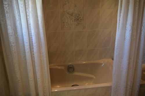 a bathroom with a tub and a shower curtain at L'Olla in Cala Ratjada