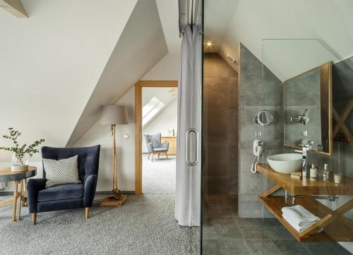 W łazience znajduje się prysznic, umywalka i krzesło. w obiekcie Villa Nova w Zakopanem