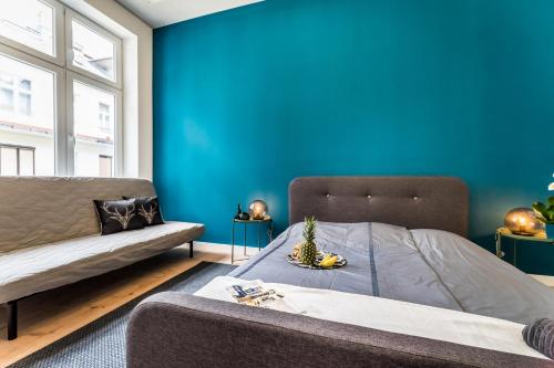 ein blaues Schlafzimmer mit einem Bett und einem Sofa in der Unterkunft Highrise Oasis Apartment in Budapest