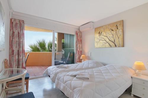 ミハスにあるApartment with panoramic sea viewのベッドルーム1室(大型ベッド1台、テーブル、椅子付)