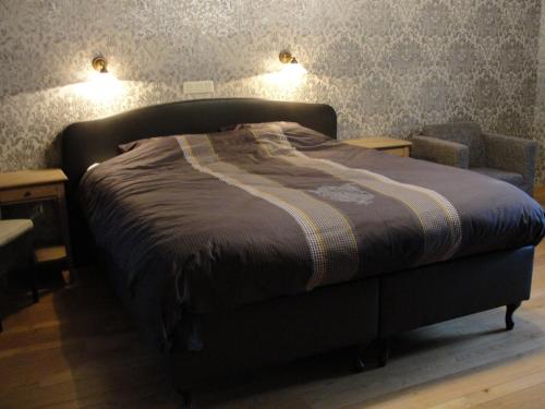 een bed in een slaapkamer met 2 lampen aan de muur bij B&B Hedera in Herne
