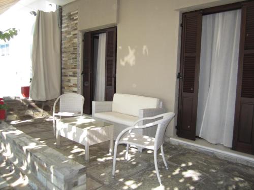 a patio with chairs and a table and a couch at Spyrou Studios & Apartments in Platanidia