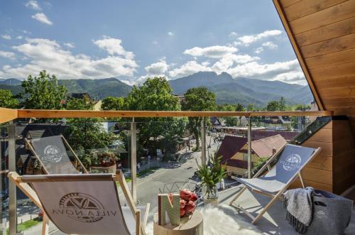 a patio area with chairs, tables, and tables with umbrellas at Villa Nova in Zakopane