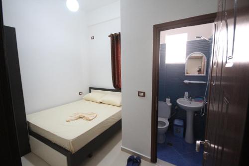 a small bathroom with a bed and a sink at Hotel Agreno in Berat