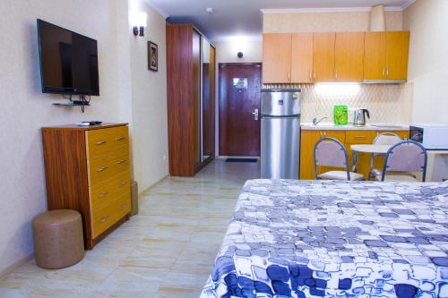 1 dormitorio con 1 cama y cocina con TV en Apartment ZARINA in apart-otel RESIDENC en Batumi