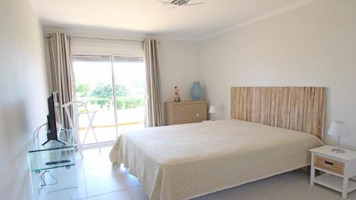 une chambre avec un lit et une télévision et un balcon dans l'établissement Villa Carpe Diem, aux Issambres