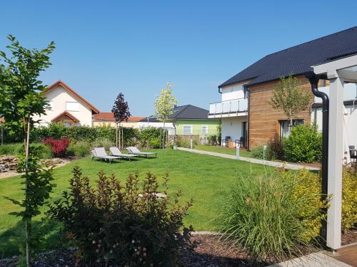 um jardim com espreguiçadeiras e uma casa em Pension Laa Natura em Laa an der Thaya