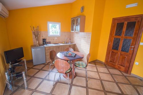 a kitchen with yellow walls and a table and chairs at Apartments Ćuković in Risan