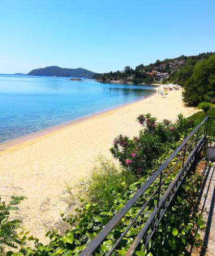 a view of a beach with a fence and the water at The House On The Beach in Paleo Tsifliki