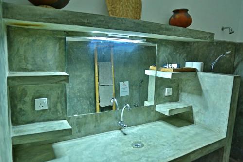 ein Badezimmer mit einem Waschbecken und einem großen Spiegel in der Unterkunft Red Parrot Beach Villa in Ambalangoda