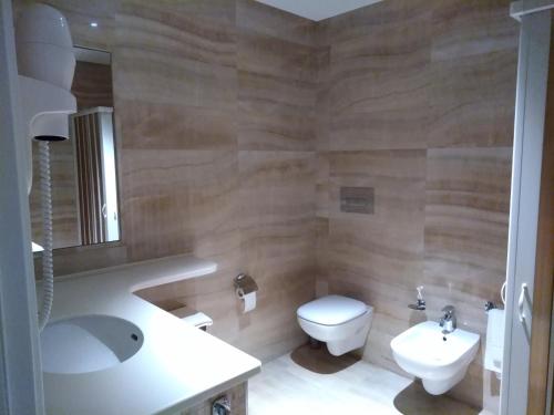 a bathroom with a sink and a toilet and a mirror at Family Center Hotel in Polla