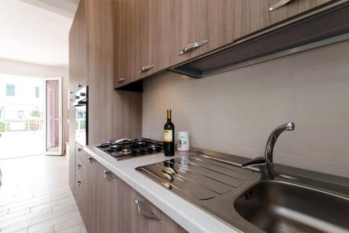 a kitchen with a sink and a bottle of wine at Villa Demì in Lido di Pomposa