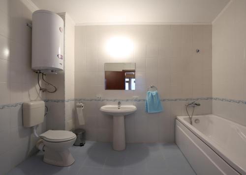 a bathroom with a sink and a toilet and a tub at Holiday Home Paulovnia in Asparukhovo