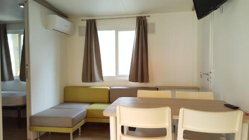 a room with a table and chairs and a couch at Campeggio del Garda in Peschiera del Garda