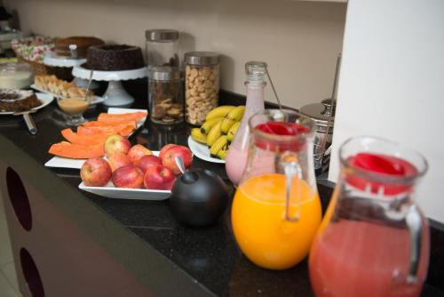 un bancone con un mucchio di frutta e succo di Hotel Bem Estar a Ibitinga