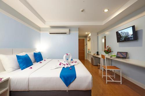 una camera da letto con un grande letto con un vestito blu sopra di Anya Nana at Sukhumvit Bangkok a Bangkok