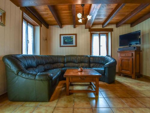 ein Wohnzimmer mit einem Ledersofa und einem Couchtisch in der Unterkunft Holiday home 1km from the Gouffre de Padirac in Padirac