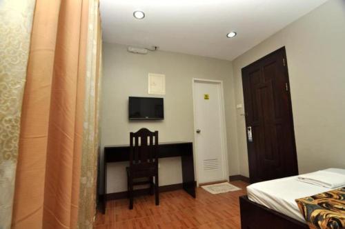 a bedroom with a desk and a chair in a room at Harbour Gardens Tourist Inn in Tagbilaran City