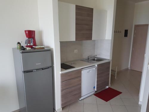 a small kitchen with a sink and a refrigerator at Apartments Alen in Umag