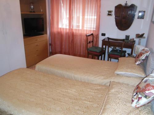 a hotel room with two beds and a table at B&B Villa Olmo in Como